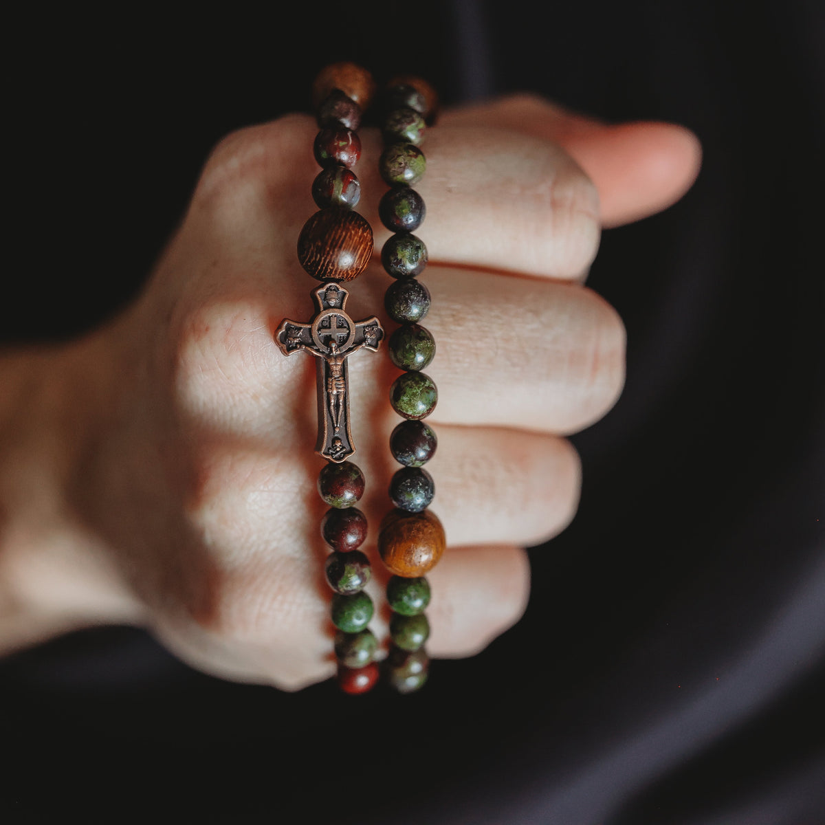 Dark green and wooden beads with copper cross.